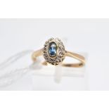 A 9CT GOLD SAPPHIRE AND DIAMOND CLUSTER RING, the central collet set oval sapphire within a single