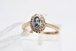 A 9CT GOLD SAPPHIRE AND DIAMOND CLUSTER RING, the central collet set oval sapphire within a single