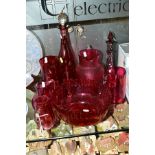 A GROUP OF CRANBERRY COLOURED GLASS ITEMS, to include five various jugs, tallest 18cm, smallest 12.