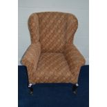A 19TH CENTURY UPHOLSTERED WING BACK ARMCHAIR, on mahogany cabriole legs and castors