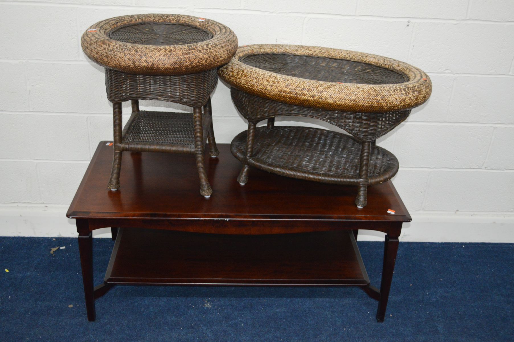 A PRIORY MAHOGANY COFFEE TABLE, with a spring top, together with two oval wicker occasional tables
