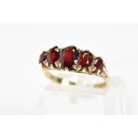 A 9CT GOLD RED PASTE FIVE STONE RING, designed as five graduated oval cut red pastes to the