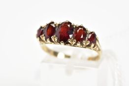 A 9CT GOLD RED PASTE FIVE STONE RING, designed as five graduated oval cut red pastes to the