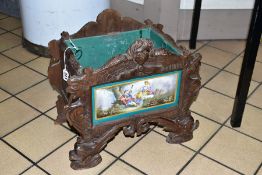 A 19TH CENTURY BLACK FOREST WOODEN PLANTER, with porcelain panel depicting a male figure playing the