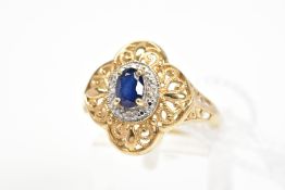 A SAPPHIRE AND DIAMOND CLUSTER RING, the central oval cut sapphire within a surround set with four
