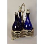 A VICTORIAN PLATED TREFOIL DECANTER STAND, containing three blue glass decanters with novelty