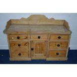 A VICTORIAN PINE SIDEBOARD, with raised back and sides, seven assorted drawers and central cupboard,