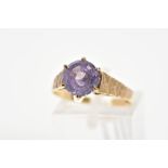 A 9CT GOLD AMETHYST RING, the circular amethyst within a six claw setting to the tapered, slightly