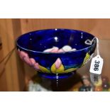 A MOORCROFT POTTERY FOOTED BOWL, 'Magnolia' pattern on blue ground, impressed backstamp and