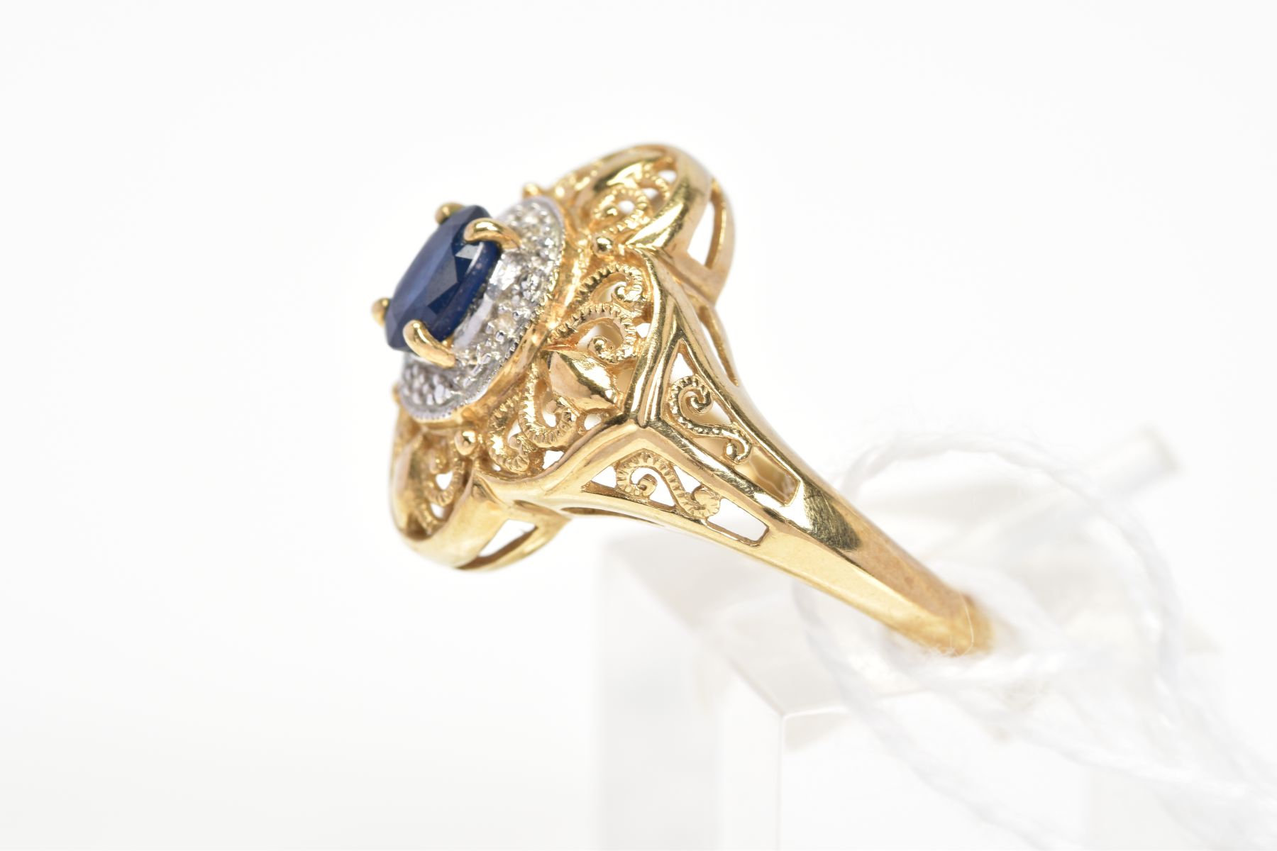 A SAPPHIRE AND DIAMOND CLUSTER RING, the central oval cut sapphire within a surround set with four - Image 2 of 3