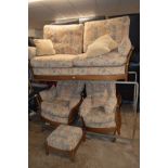 AN ERCOL THREE PIECE LOUNGE SUITE with a medium oak wooden frame, consisting of a three seater sofa,