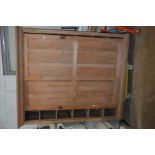 A VINTAGE PITCH PINE CUPBOARD with two sliding six raised panel doors covering five full width
