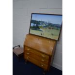 A GOLDEN OAK BUREAU, with three drawers, together with an Edwardian footstool and a framed oil