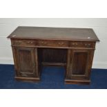 A DISTRESSED EDWARDIAN MAHOGANY KNEE HOLE DESK with three various drawers, width 130cm x depth