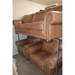 A FAWN LEATHER THREE PIECE LOUNGE SUITE consisting of a three seater sofa, width 227cm and two