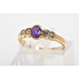 A 9CT GOLD AMETHYST AND DIAMOND RING, designed with a central oval amethyst in a collet setting with