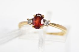 A 9CT GOLD GARNET AND PASTE RING, designed as a central oval shape garnet flanked by a circular