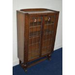 A MID 20TH CENTURY OAK LEAD GLAZED DOUBLE BOOKCASE