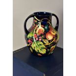 A MOORCROFT POTTERY TWIN HANDLED VASE, 'Queens Choice' pattern, blue backstamp, monogrammed and year