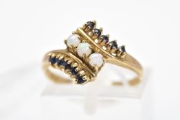 A 9CT GOLD SAPPHIRE AND OPAL RING, of crossover design set with a central diagonal line of three