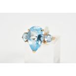 A THREE STONE TOPAZ DRESS RING, designed as a central pear shape topaz within a three claw setting