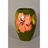A MOORCROFT POTTERY VASE, 'Hibiscus' pattern on green ground, impressed backstamp and painted