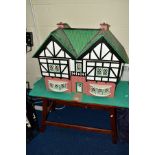 A MODERN WOODEN DOLLS HOUSE, modelled as a double fronted Tudorbethan Villa, front opening to reveal