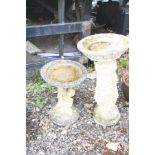 TWO COMPOSITE BIRD BATHS one with two children holding the bowl aloft, height 52cm, the other with