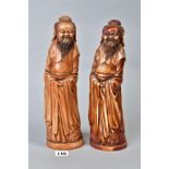 TWO NEAR IDENTICAL CHINESE CARVED AND BROWN STAINED IVORY FIGURES OF IMMORTALS, on oval bases with