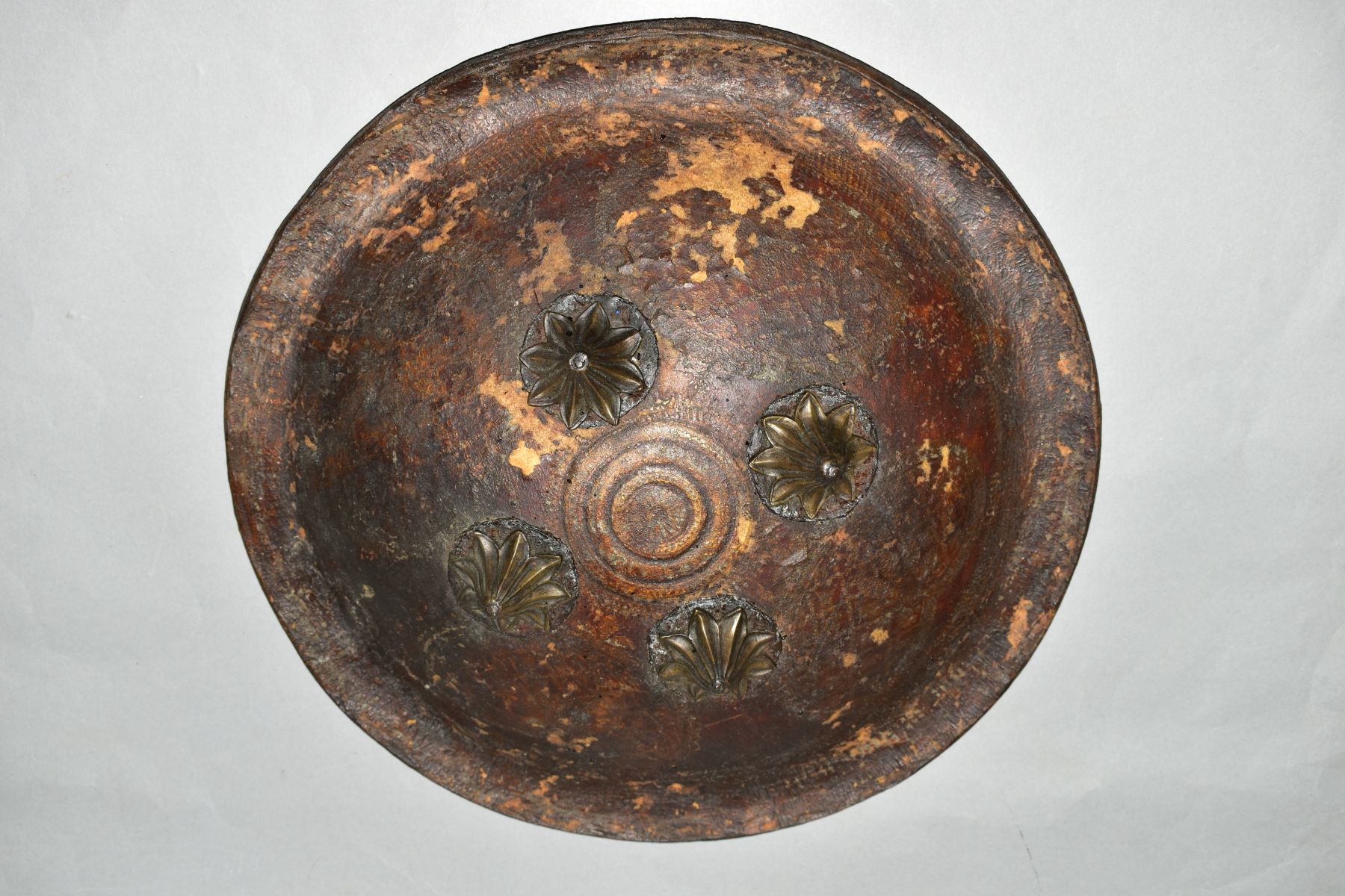 AN INDIAN LEATHER SHEILD WITH FOUR IRON BOSSES, probably 19th Century, leather straps verso and