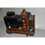 A THORNTON PICKARD RUBY ENLARGER with mahogany case, lens and blacked tin lamp box and lens tube (