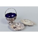 AN EDWARDIAN SILVER PEDESTAL SUGAR BOWL, with swing handle, blue glass liner, foliate pierced frame,