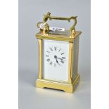 A MODERN BRASS CARRIAGE CLOCK, white enamel dial with Roman numerals, swing handle, fire bevel