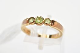 A 9CT GOLD GEM RING, designed as three graduated circular green gems assessed as peridot, in part