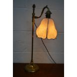 AN EARLY TO MID 20TH CENTURY BRASS TABLE LAMP with a swinging shaped arm and hanging fabric shade on