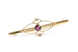 AN EARLY 20TH CENTURY 9CT GOLD GARNET AND SPLIT PEARL BROOCH, of elongated design, the central