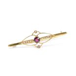 AN EARLY 20TH CENTURY 9CT GOLD GARNET AND SPLIT PEARL BROOCH, of elongated design, the central