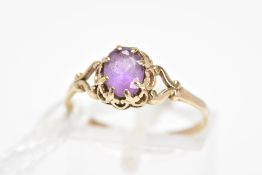 AN AMETHYST RING, the central oval amethyst within an eight claw setting to the scalloped