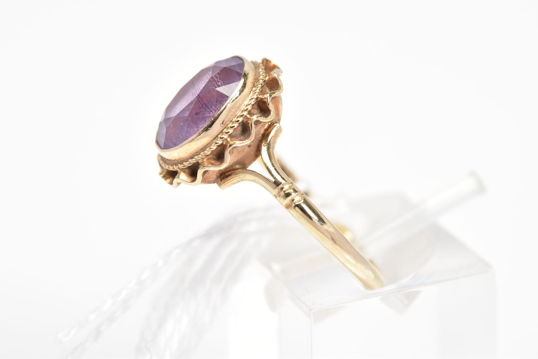 A 9CT GOLD AMETHYST RING, the oval amethyst within a collet setting with rope twist and undulating - Image 2 of 3