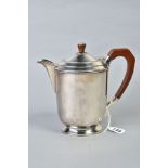 AN ELIZABETH II SILVER HOT WATER JUG OF OVAL FORM, brown bakelite handle and finial, makers