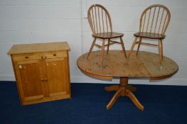 A PAIR OF DISTRESSED ERCOL BLONDE HOOP BACK CHAIRS together with a pine extending pedestal table and