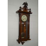 AN EARLY 2OTH CENTURY WALNUT VIENNA WALL CLOCK, with an ceramic eagle pediment (sd), the enamel