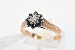 A 9CT GOLD SAPPHIRE AND DIAMOND CLUSTER RING, the central single cut diamond in an illusion