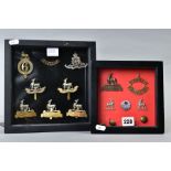 TWO SMALL GLAZED FRAMES containing a number of WWI era cap badges, collar dogs buttons and