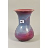 A RUSKIN POTTERY HIGH FIRED VASE OF BULBOUS SHAPE BELOW A FLARED RIM, sang de boeuf and lavender