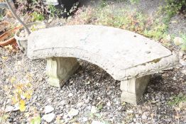 A CURVED COMPOSITE GARDEN BENCH with scroll detailed supports, width 140cm x height 47cm