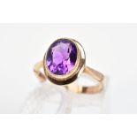 A 9CT GOLD AMETHYST RING, the oval amethyst in a millegrain setting to the plain surround and