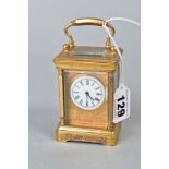 A LATE 19TH/EARLY 20TH CENTURY GILT METAL CARRIAGE CLOCK OF SMALL SIZE, engraved decoration to the