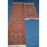 A LATE 20TH CENTURY WOOLLEN RED GROUND SHIRAZ STYLE CARPET RUNNER 250cm x 67cm together with a