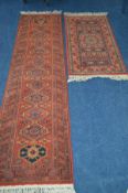 A LATE 20TH CENTURY WOOLLEN RED GROUND SHIRAZ STYLE CARPET RUNNER 250cm x 67cm together with a